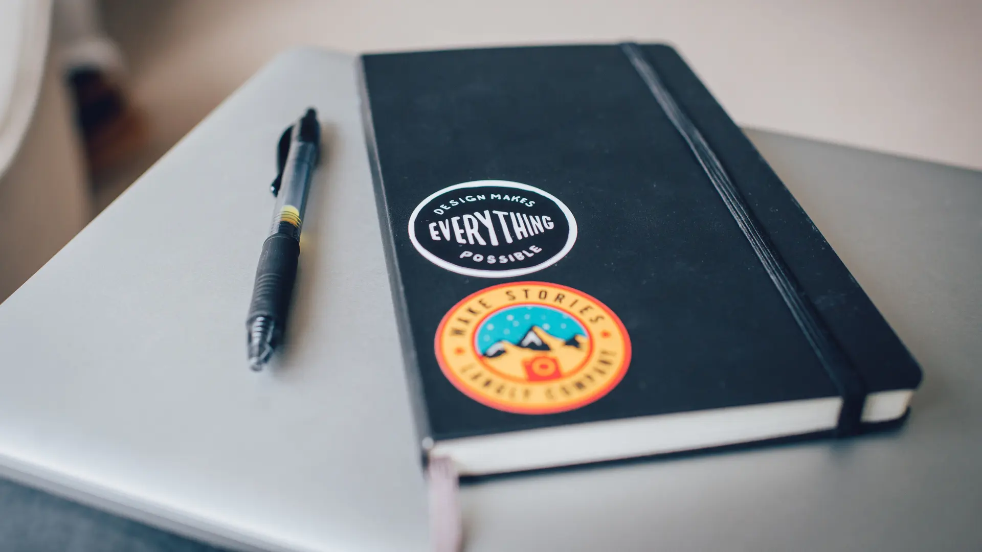 Masada duran açık bir defter ve kalem.