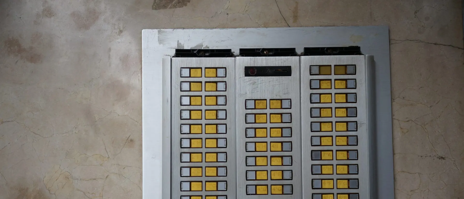 An apartment intercom panel with buzzer buttons.